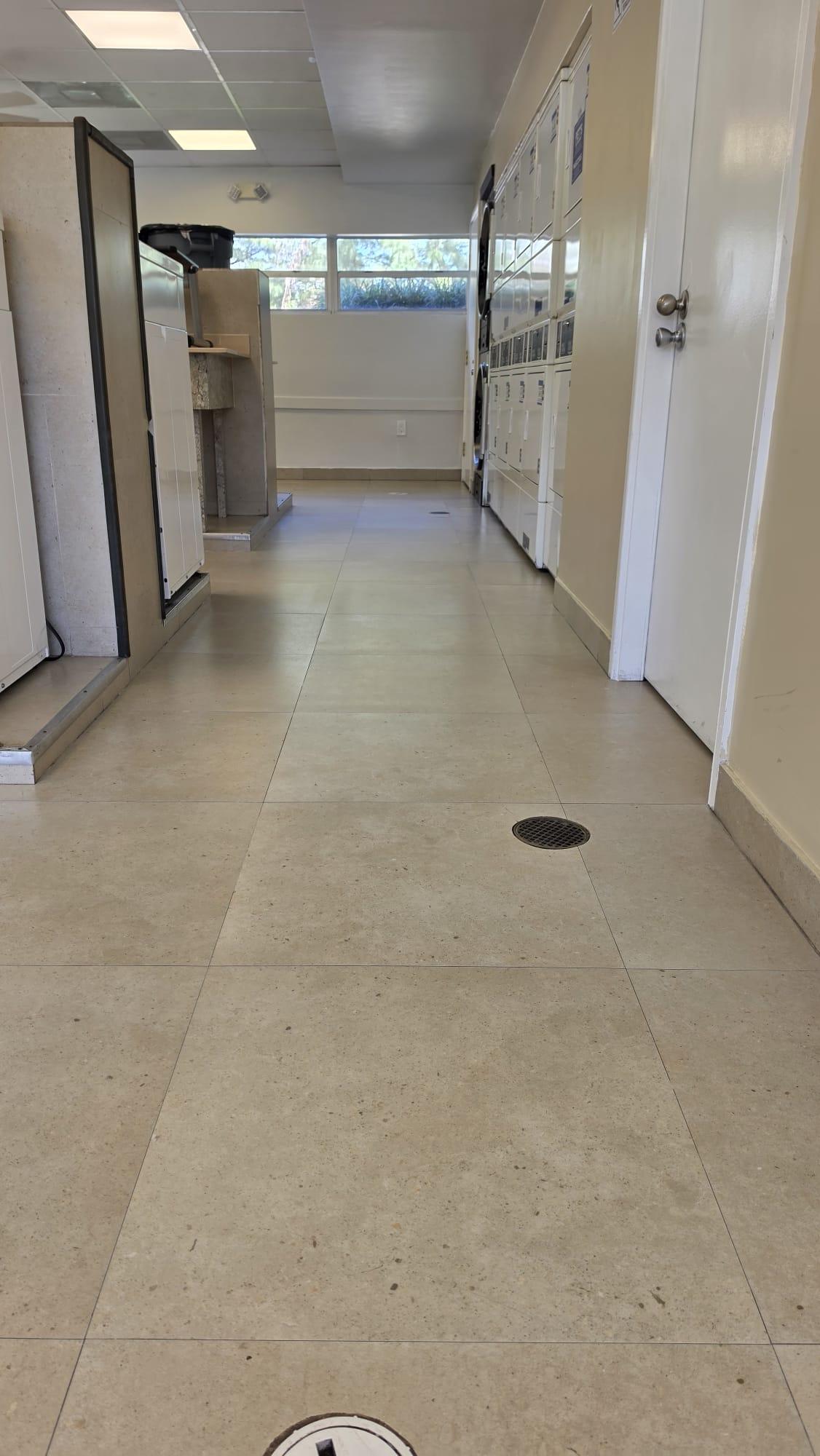 Porcelain Hallway Before Ceramic Coating, Apartment Laundry Room Porcelain hallway floor before ceramic coating, soil held in the surface texture and grout, apartment laundry room, Miami-Dade