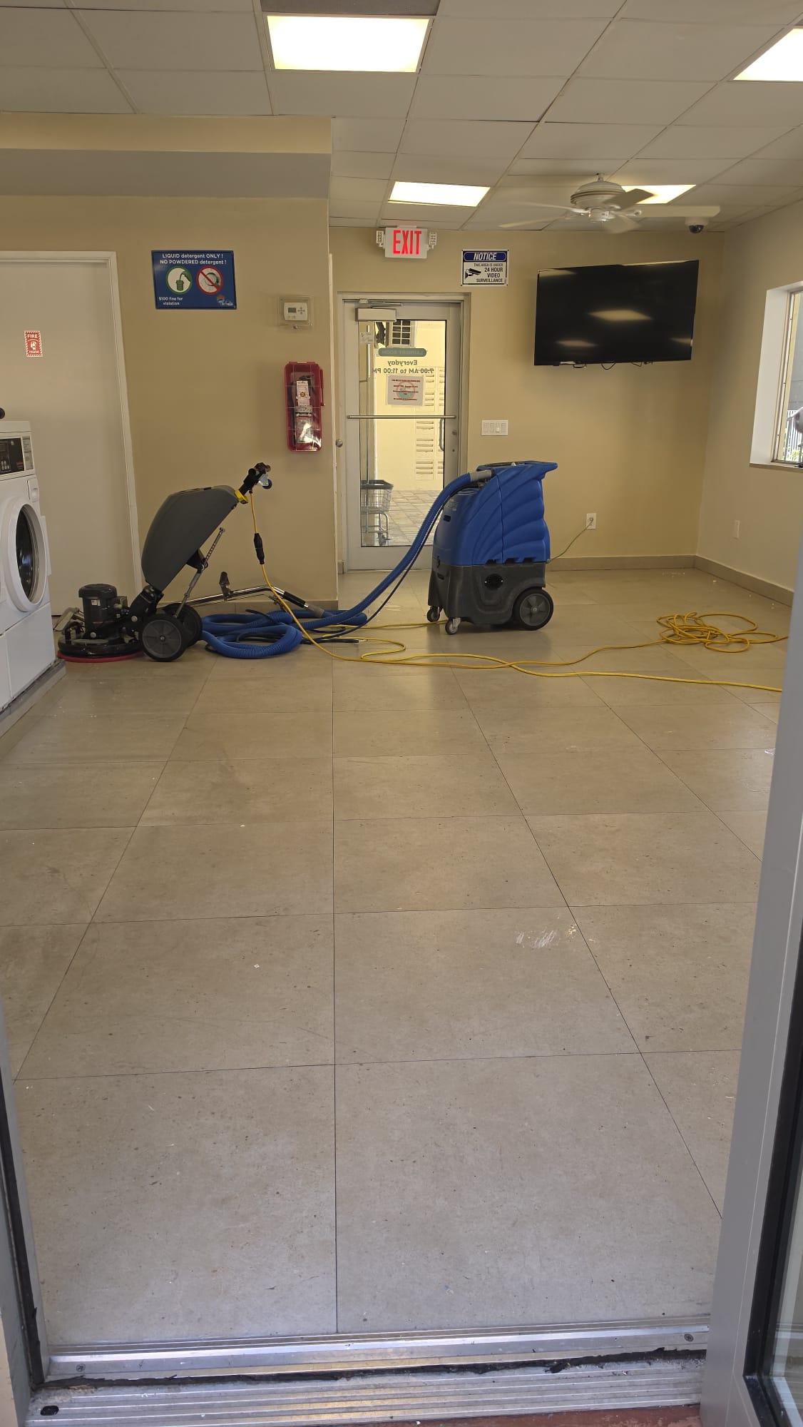 Laundry room tile before ceramic floor coating, with the cleaning equipment set up