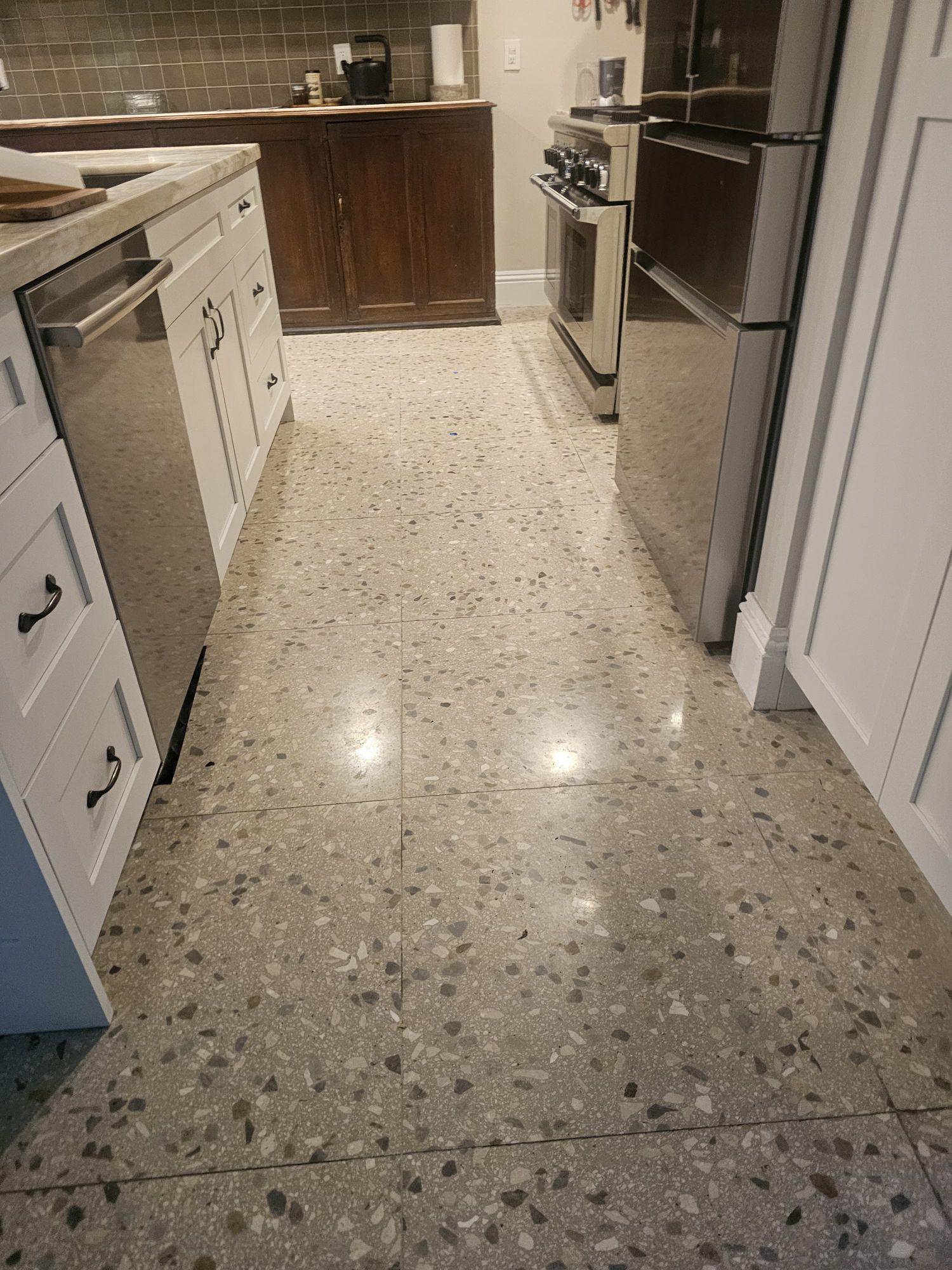 Dark, open grout joints on terrazzo tile in a Coconut Grove kitchen, before the grout was filled
