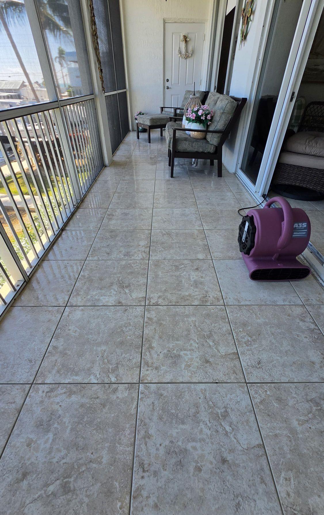 Ceramic tile on a screened balcony in an Islamorada condo, with an air mover drying the floor after cleaning